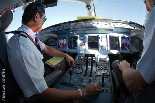 Cockpit of jet aircraft in flight. The pilots of the passenger plane at work.