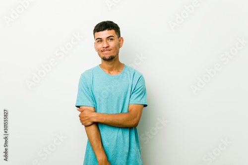 Young hispanic man unhappy looking in camera with sarcastic expression.