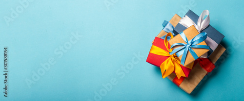 Stack of gifts on a blue background. Gift concept for a loved one, holiday, Christmas. Banner. Flat lay, top view