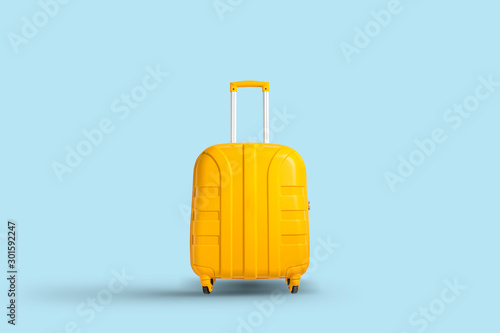 Yellow suitcase on a blue background. Travel and vacation concept in triples. Flat lay, top view