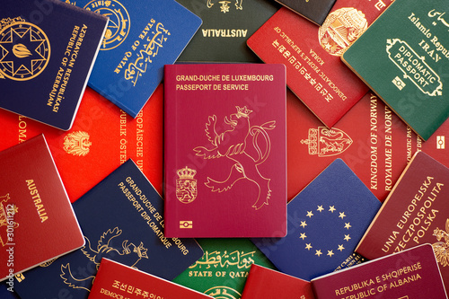 An official biometric passport of Luxembourg against the background of multi-colored passports of the world.