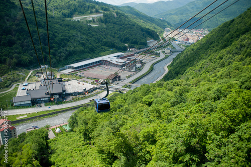 the river flows through the city in the mountains in summer. ski lift, mountain resort