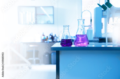 two science glass flask with purple solution on laboratory water sink for chemistry education background