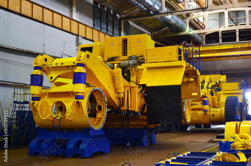 Production process of heavy mining trucks at the factory. Dump truck on the Industrial conveyor in the workshop of an automobile plant. Manufacturer of haulage and earthmoving equipment, haul trucks