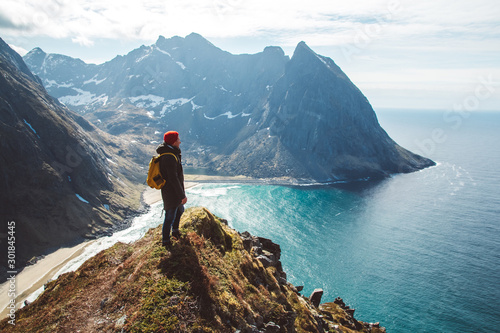 Man stand on cliff edge alone enjoying aerial view backpacking lifestyle travel adventure outdoor vacations