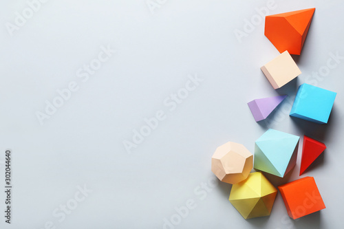 Colorful paper geometric figures on grey background