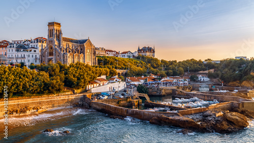 Panoramic view of Biarritz cityscape, coastline with its famous sand beaches and port for small boats. Golden hour. Aquitaine, France.