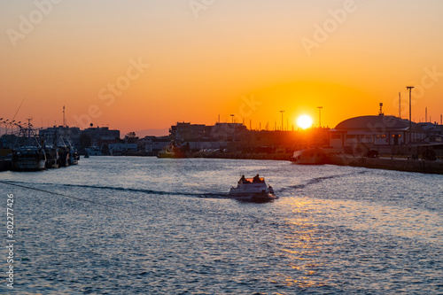 Little boat for fishing in Fiumicino port at sunrise.