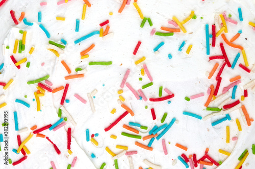 Candy sprinkles confetti. Sugar sprinkle dots. Sweet confetti on white glaze background. Cupcake, donuts, dessert, sugar, bakery background.