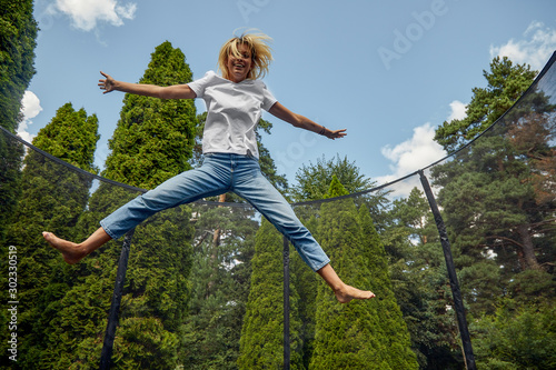 Young Female Jumping On Trampoline Outdoors