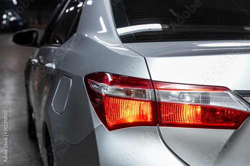 Widok makro nowoczesnych srebrnych świateł ksenonowych samochodowych tylnych świateł, zderzaka, tylnej klapy bagażnika. Zewnętrzna część nowoczesnego samochodu