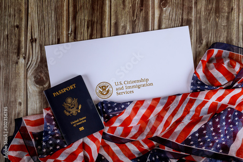 USA passport and naturalization certificate of citizenship US flag over wooden background