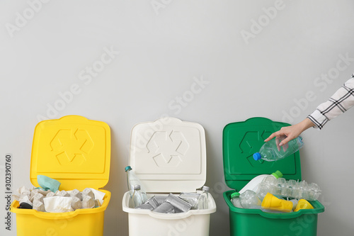 Woman throwing garbage into container. Recycling concept