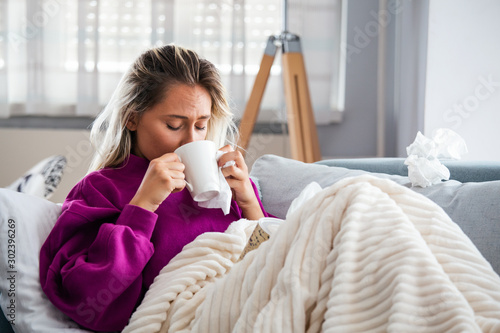 Cold And Flu. Portrait Of Ill Woman Caught Cold, Feeling Sick And Sneezing In Paper Wipe. Closeup Of Beautiful Unhealthy Girl Covered In Blanket Wiping Nose. Healthcare Concept. High Resolution