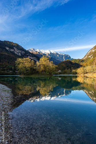 Lago di Tenno in autumn, small beautiful lake with reflections in Italian alps, Trento province, Trentino-Alto Adige, Italy, Europe