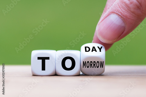 Hand turns a dice and changes the word "tomorrow" to "today", or vice versa.