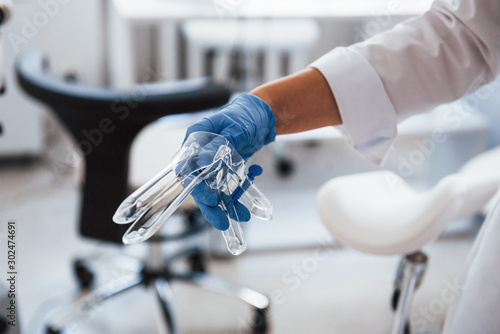 Close up view of female doctor hands that holds speculum instrument