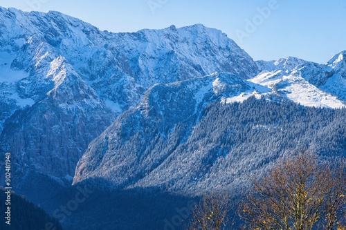 Erster Schnee im Bergwald und in hohen Felswänden in strahlendem Herbstlicht im Werdenfelser Land