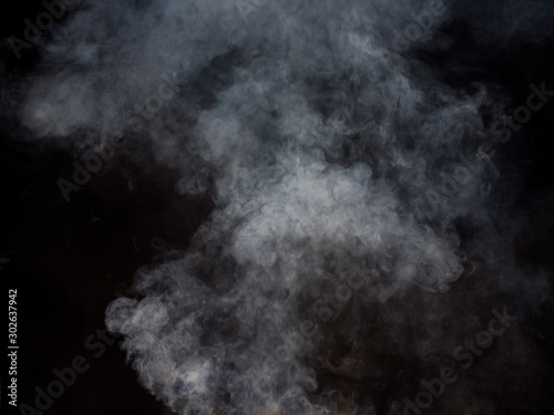 Light smoke rises against a dark background. Studio photography