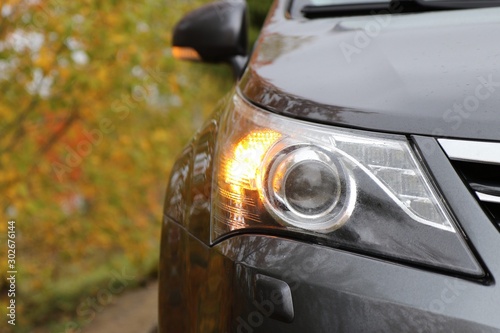 Orange car front turn signal light. Rainy day. Car headlight 