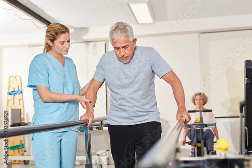 Physiotherapeutin hilft Senior auf dem Laufband