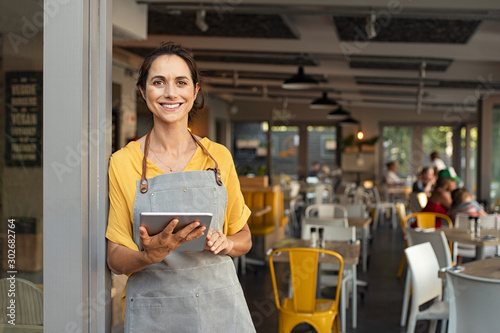 Small business owner at entrance looking at camera