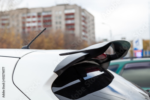 White car tuning rear spoiler view on the car parking in the street