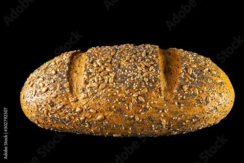 Cereal bread slightly inclined towards the viewer, on a black background