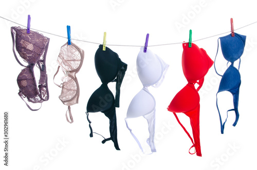 Female bras on clothespins rope on white background isolation