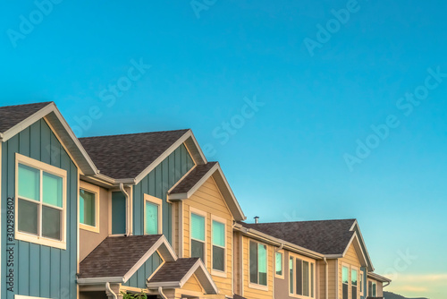 Exterior of upper storey of townhomes with blue sky background on a sunny day