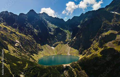Aerial view of Black Lake below Mount Rysy. It overlooks the nearby lake of Morskie Oko, or Eye of the Sea in Tatra Mountains, in southern Poland. Blue sky and clouds. Summer