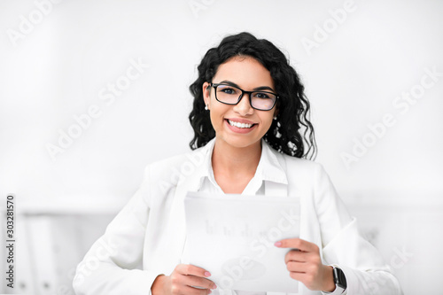 Attractive recruiter holding documents, looking at camera
