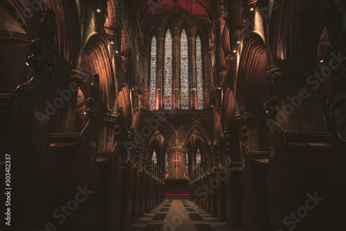 GLASGOW, SCOTLAND, DECEMBER 16, 2018: Magnificent perspective view of interiors of Glasgow Cathedral, known as High Kirk or St. Mungo, with huge stained glasses. Scottish Gothic architecture.