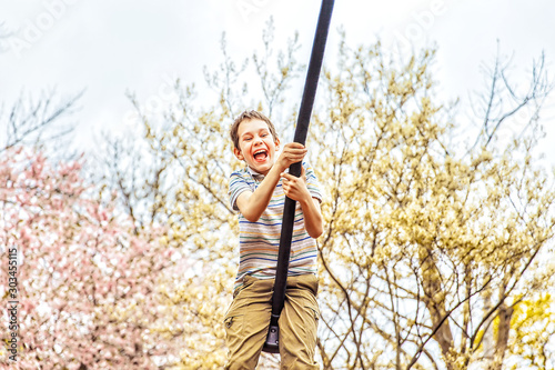 cheerful boy swinging at park. playful child having fun at bungee