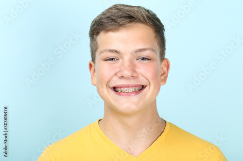 Portrait of young man with dental braces on blue background