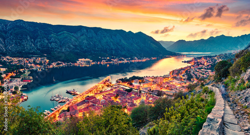 Great summer sunset in Kotor port. Aerial evening view of Kotor bay and Old Town from hill of Lovcen Mountain. Beautiful world of Mediterranean countries. Traveling concept background.