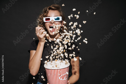 Happy cute young woman eat popcorn watch cinema.