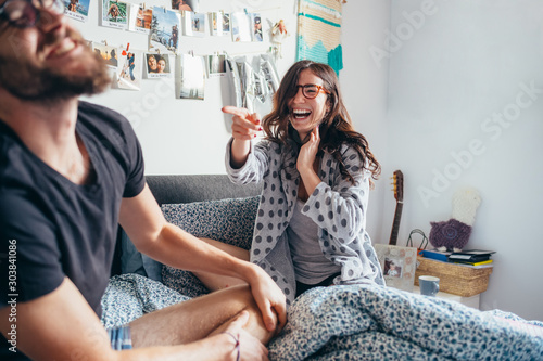Young happy couple playing laughing on bed indoor home laughing