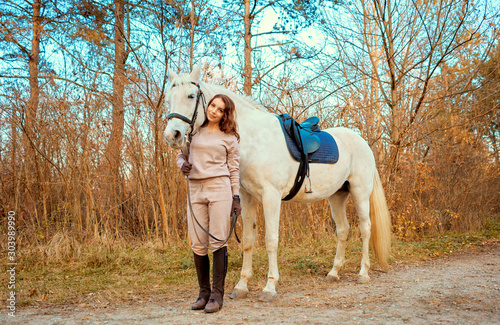 girl riding a white horse in the woods