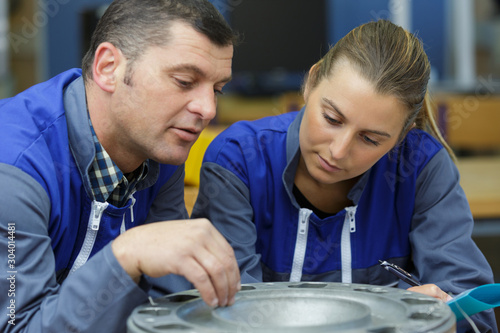 young male and female technicians in metalworks factory