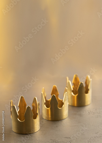 Three gold crowns on black background, symbol of Tres Reyes Magos ( Three Wise Men) who come bringing gifts for the kids on Epiphany or Dia de Reyes Magos.