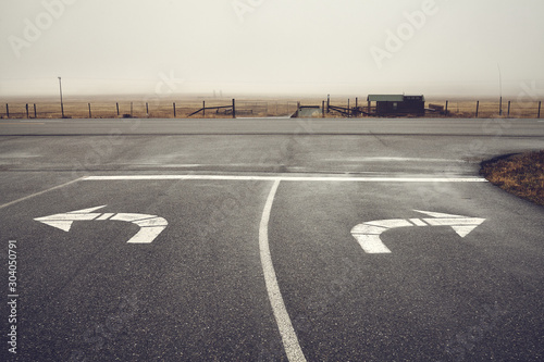 Left or right, roads intersection on a rainy day, color toning applied, Wyoming, USA.