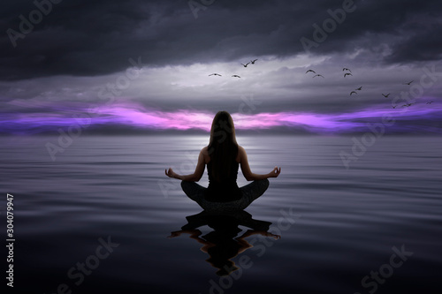 Beautiful woman doing yoga at the sea