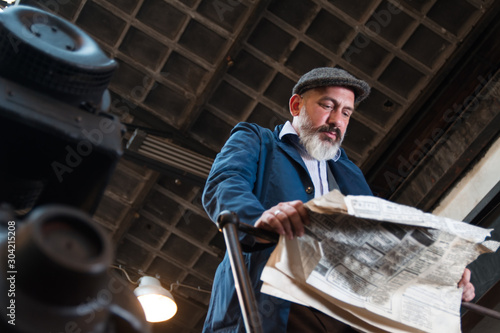 Blue collar worker reading newspaper