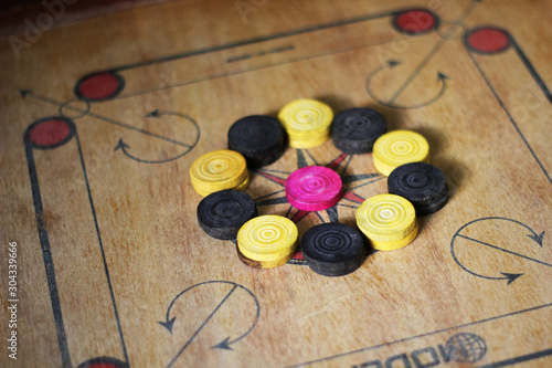 A game of carom set and ready to play.A game of carrom with pieces carrom man on the board carrom.Carom board game, selective focus.