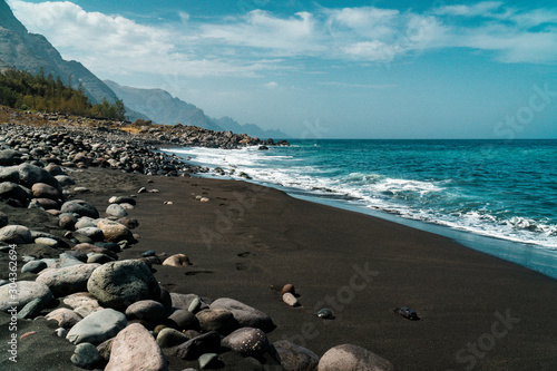 View of the black beach Playa de Guayedra with volcanic boulders in Las Palmas on Gran Canaria volcanic island, Spain, Atlantic ocean