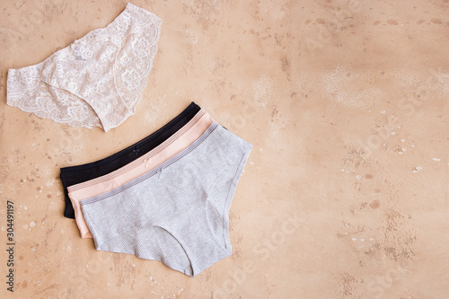 Women's organic cotton panties on beige background. Female underwear texture.