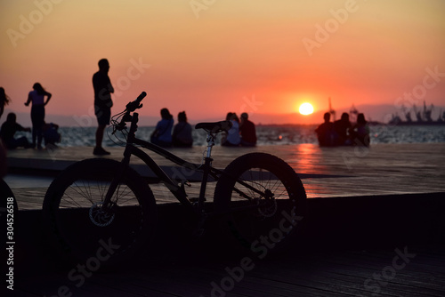 Bicycle against the background of the setting sun over the ocean.