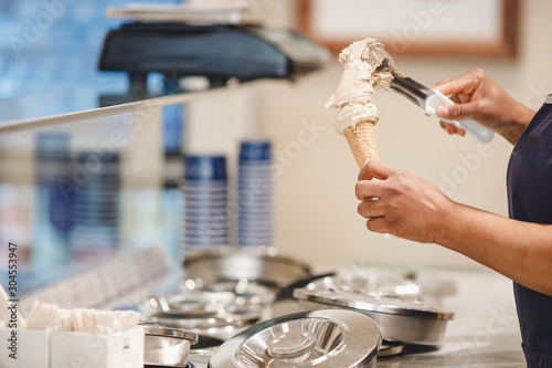Worker puts Italian ice cream cone in horn with chocolate