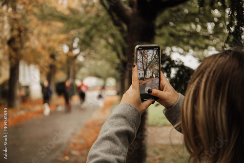 young woman taking photo with an iphone